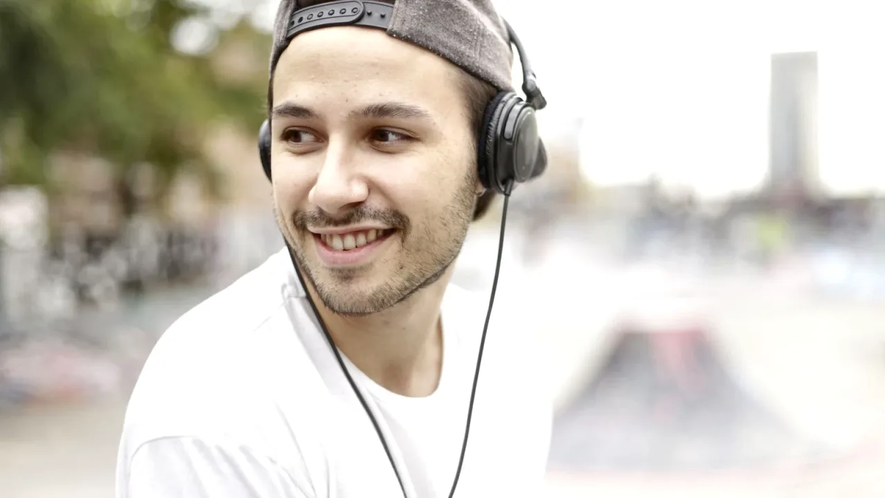 Dışarıda kulaklıkla müzik dinleyen genç